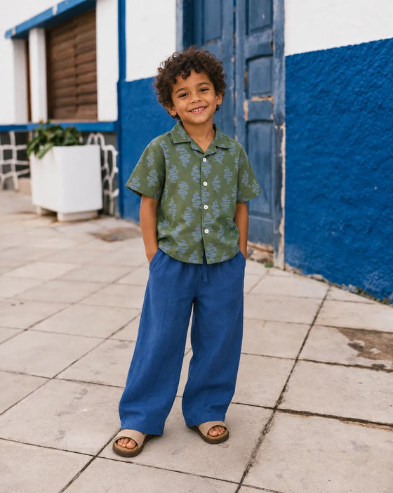 Boy in blue Mumzers Trouzers and a green printed shirt